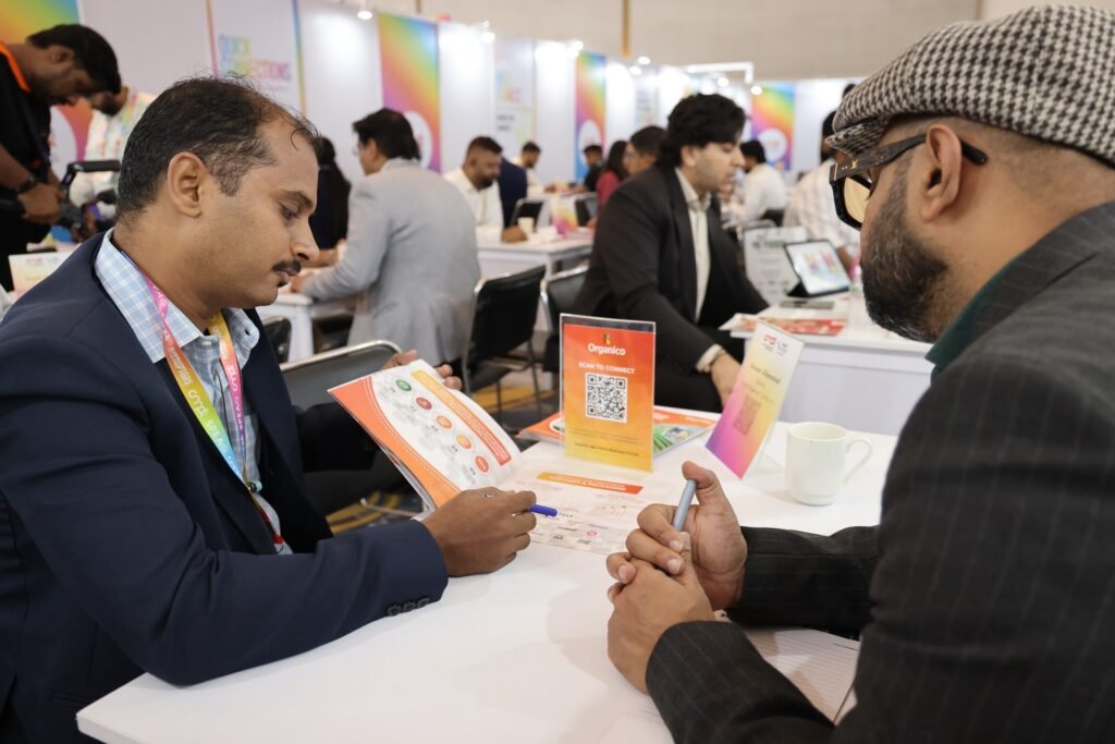 Two trade professionals reviewing a product catalog during a one-on-one B2B hosted buyer matchmaking meeting at an exhibition.